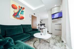 a living room with a green couch and a table at Fabesca Boutique Hotel & SPA in Sovata