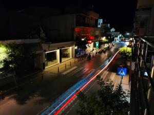 a city street at night with cars at Malia Beelight - Family & Groups in Malia