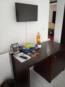 a desk with a television on the wall with a bottle of alcohol at Dalival in Baile Felix +30 photos