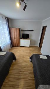 a room with two beds and a television in it at SKY BLUE LOQUS Studia i Apartmenty in Płock