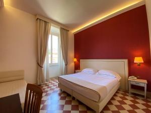 a bedroom with a bed with a red wall at Basilica Hotel in Rome