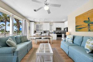 Una sala de estar con un sofá azul y una mesa. en Destiny Beach Villas #11B- Beach Oasis, en Destin