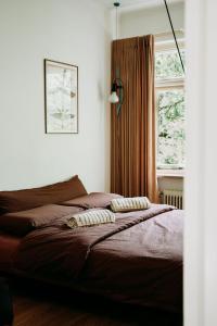 een slaapkamer met een bed met twee kussens erop bij Bungalowvilla Robin Hill, met bostuin & design interieur in Haelen