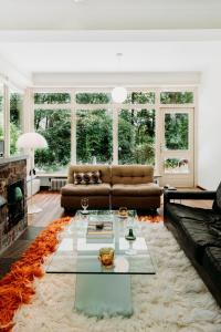 een woonkamer met een bank en een tafel bij Bungalowvilla Robin Hill, met bostuin & design interieur in Haelen