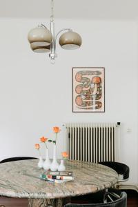 een eettafel met vazen en bloemen erop bij Bungalowvilla Robin Hill, met bostuin & design interieur in Haelen