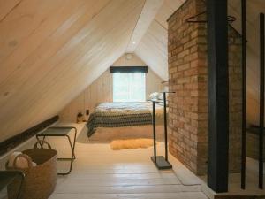 a attic bedroom with a bed and a window at Panga Sauna Hut in Lähtru