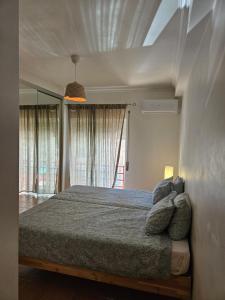 a bedroom with a bed and a large window at HOME4U - Fantastic 2 bedroom apartment, with pool in Cabanas de Tavira