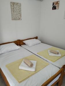two twin beds with towels on top of them at Thea's Apartment in Vrachos