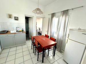 Una cocina con mesa y sillas y un refrigerador. en Sofia's House, en Pollonia