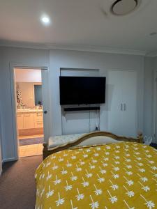 een slaapkamer met een bed en een flatscreen-tv bij Modern Luxury with Nature in Camden