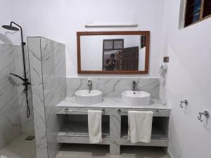 uma casa de banho com 2 lavatórios e um espelho em Nungwi Beach Front Ex Sunrise Beach Nungwi em Nungwi