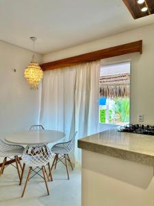 a kitchen and dining room with a table and chairs at Manay Preá, apartamento 2 quartos na melhor localização do Preá in Cruz