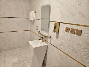 a white bathroom with a sink and a mirror at فندق السد الخليجى in Sīdī Ḩamzah +54 photos