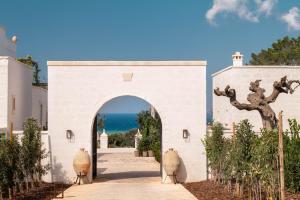 an entrance to a white building with an archway at Masseria Auraterrae in Polignano a Mare