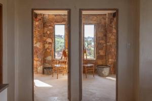 2 puertas en una habitación con una pared de piedra en Upmarket Sea View Apartment, en Cape St. Francis