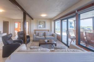 una sala de estar con un sofá y una mesa en Upmarket Sea View Apartment, en Cape St. Francis