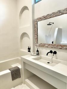 een witte badkamer met een wastafel en een bad bij Kacchapa Beach Resort and Restaurant in Sekongkang