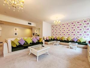 a living room with a black couch with colorful pillows at ELAN RIMAL SADAF Suites in Dubai