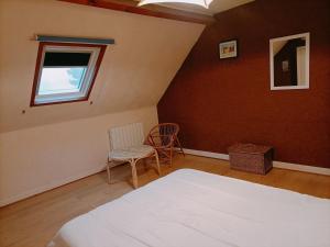 LocmariaにあるMaison cosy 2 chambres avec jardin, proche plage et côte sauvage, idéale pour famille - FR-1-418-145のベッドと椅子2脚と窓のある寝室