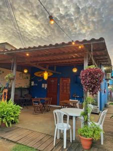 a patio with a table and chairs and a blue wall at Estação Noronha in Fernando de Noronha