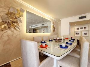 a dining room with a white table and chairs at ELAN RIMAL SADAF Suites in Dubai +17 photos