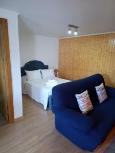 a bedroom with a bed and a blue couch at Playa de Seiruga in Malpica
