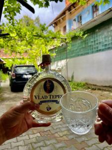 Casa Ming في براشوف: شخص يحمل زجاجة وكأسًا