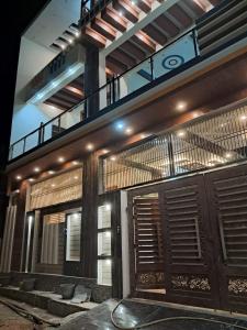 a building with a balcony and a wooden door at Awadh Royals Homestay Ayodhya in Ayodhya