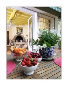 a table with bowls of fruit on a porch at Villa Aimée Luxury Apartments with Heated Pool in Vals-les-Bains
