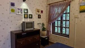 a living room with a tv and a window at Mận Đào Villa in Ho Chi Minh City
