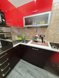a kitchen with red cabinets and a sink at Villa Mattei Dreams in Rome