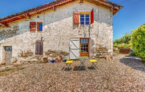 een stenen huis met twee stoelen ervoor bij Cozy Home In Armillac With Wifi in Armillac