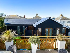 a black house with plants in front of it at Meadow View Apartments are 2 and 3 bedroomed with private parking in Newquay