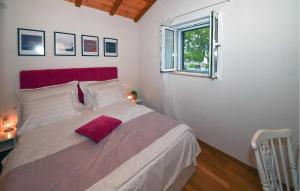 a bedroom with a large white bed with a red headboard at Villa Silentio Dalmatia in Makarska