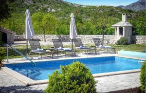 a swimming pool with lounge chairs and umbrellas at Villa Silentio Dalmatia in Makarska