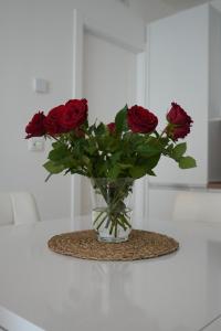 eine Vase voller roter Rosen auf einem Tisch in der Unterkunft La Mia Casa Romana in Rom
