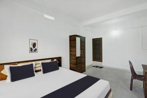 ein Schlafzimmer mit einem großen Bett und einem Tisch in der Unterkunft OYO Hill Way Rooms in Wayanad