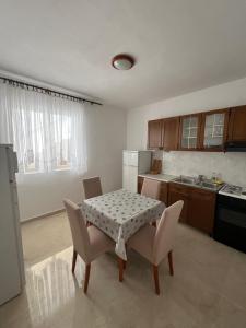 eine Küche mit einem Tisch und zwei Stühlen und einem Tisch und einem Tisch und Stühlen in der Unterkunft Rooms with shared kitchen "Milica" in Drvenik