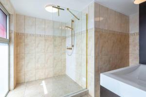a bathroom with a shower with a tub and a bath tub at NEW! Right at the Beach! Curazure Beach Condo, Jan Thiel in Willemstad +38 photos