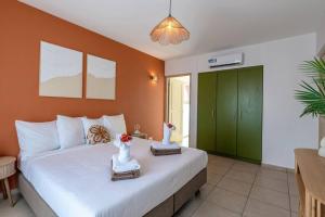 a bedroom with a large bed and a green cabinet at NEW! Right at the Beach! Curazure Beach Condo, Jan Thiel in Willemstad