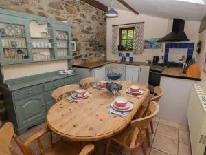 a kitchen with a wooden table and some chairs at Preseli Hills Cottage in Fishguard