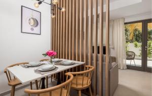 a dining room with a white table and chairs at Awesome Apartment In Omisalj in Omišalj