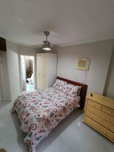 ein Schlafzimmer mit einem Bett und einer Kommode darin in der Unterkunft Apartamento em Enseada - Guarujá in Guarujá
