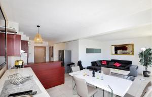 a kitchen and a living room with a white table at Beautiful Apartment In Le Barcarès in Le Barcarès +15 photos