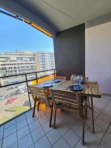 a wooden table and chairs in a room with a balcony at Le 19 #Terrasse#Parking in Clermont-Ferrand
