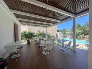 a dining room with tables and chairs and a pool at Ricordi Siciliani - Charme Rooms in San Vito lo Capo