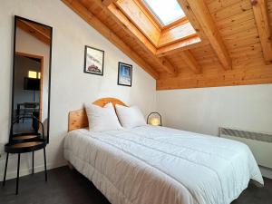 a bedroom with a large white bed with a skylight at Appartement T2 au centre de Samoëns avec parking, animaux acceptés - FR-1-624-43 in Samoëns