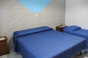 a bedroom with two beds with blue sheets at La Casetta di Gabri in San Vito Chietino