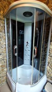a shower in a room with a stone wall at Gutsulska rodzynka in Yaremche