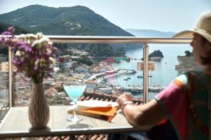 a woman sitting at a table with a glass of wine at Alegeo Apartment in Parga